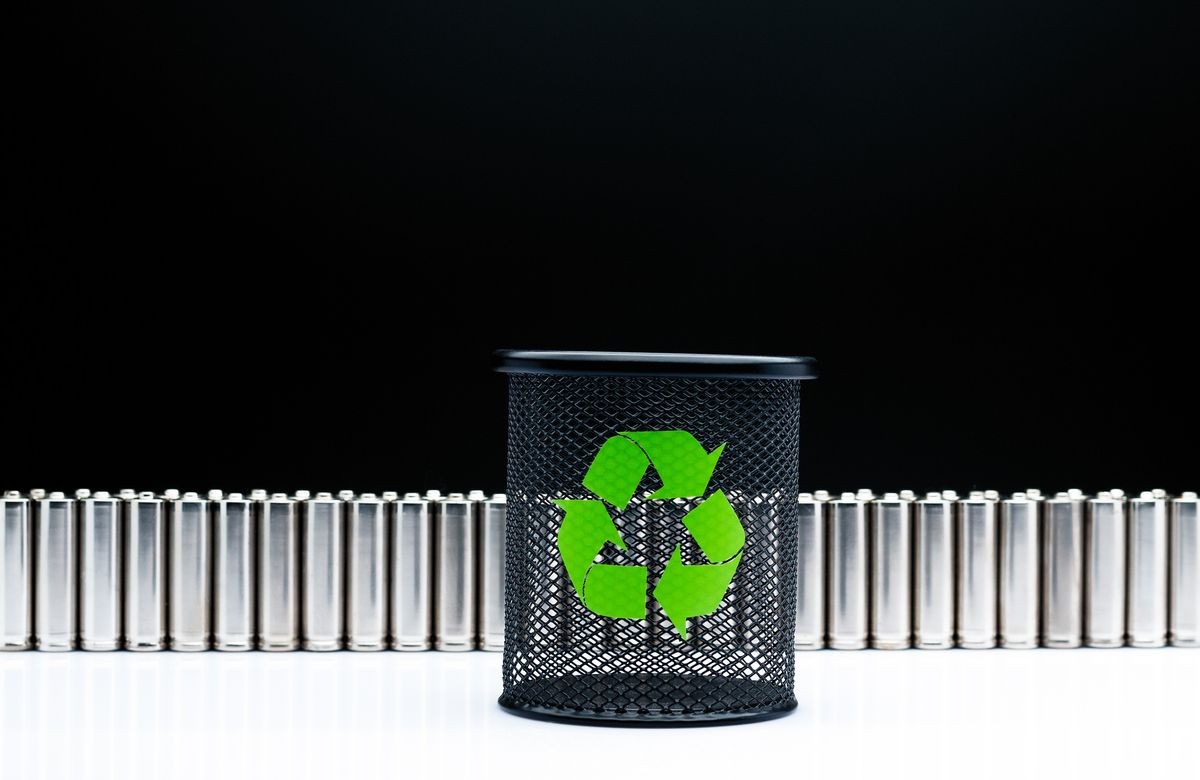 Ecology recycling concept, nature energy, used or new battery on recycle garbage bin, rechargeable AA accumulator, alkaline batteries in row on black background